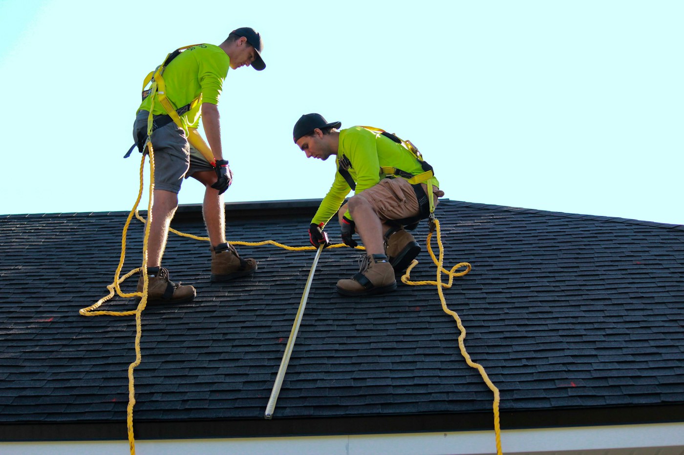 Roof professionals inspecting shingles after possible storm damage